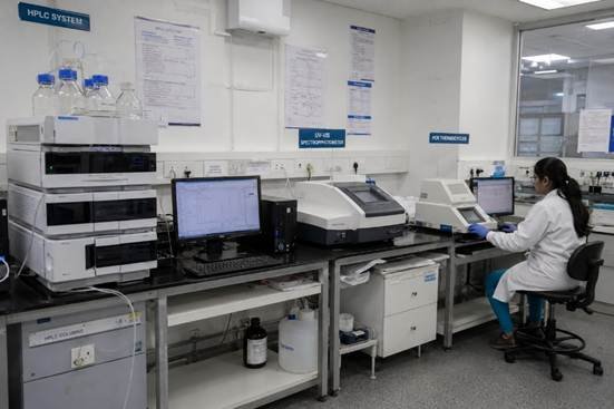 Analytical instruments workstation in a Bangalore pharmaceutical QC laboratory — UV-Vis spectrophotometer and PCR thermocycler visible on bench