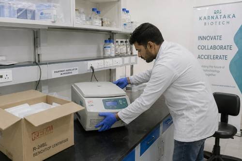 Startup R&D lab being equipped in a Karnataka biotech incubator — researcher unpacking and installing laboratory instruments at new benches