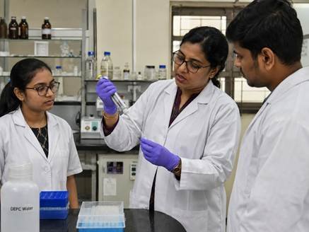 Researcher demonstrating correct pipetting technique with laboratory pipettes in a Karnataka research institute
